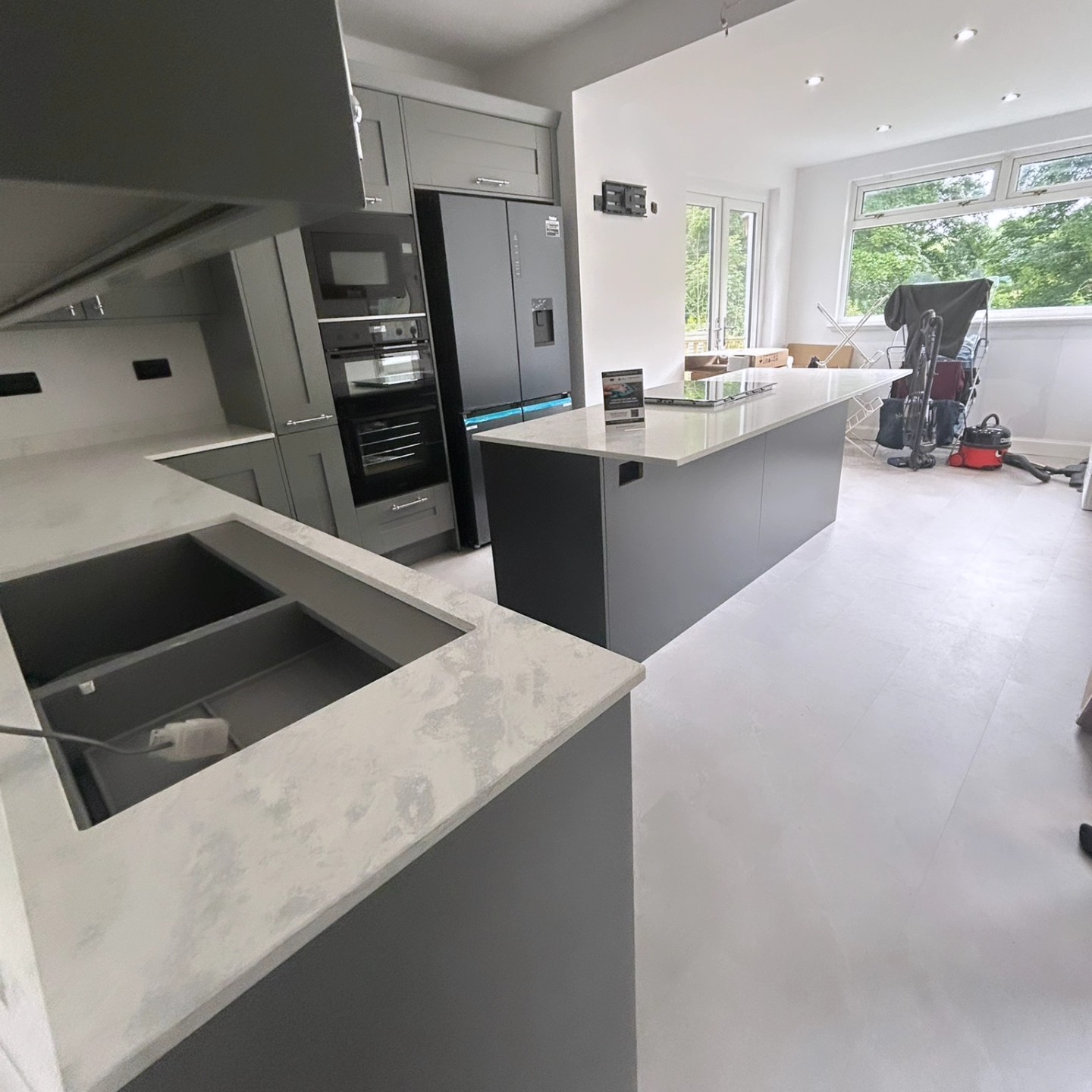 Structural open-plan living, kitchen and utility space with double doors onto a decking balcony
